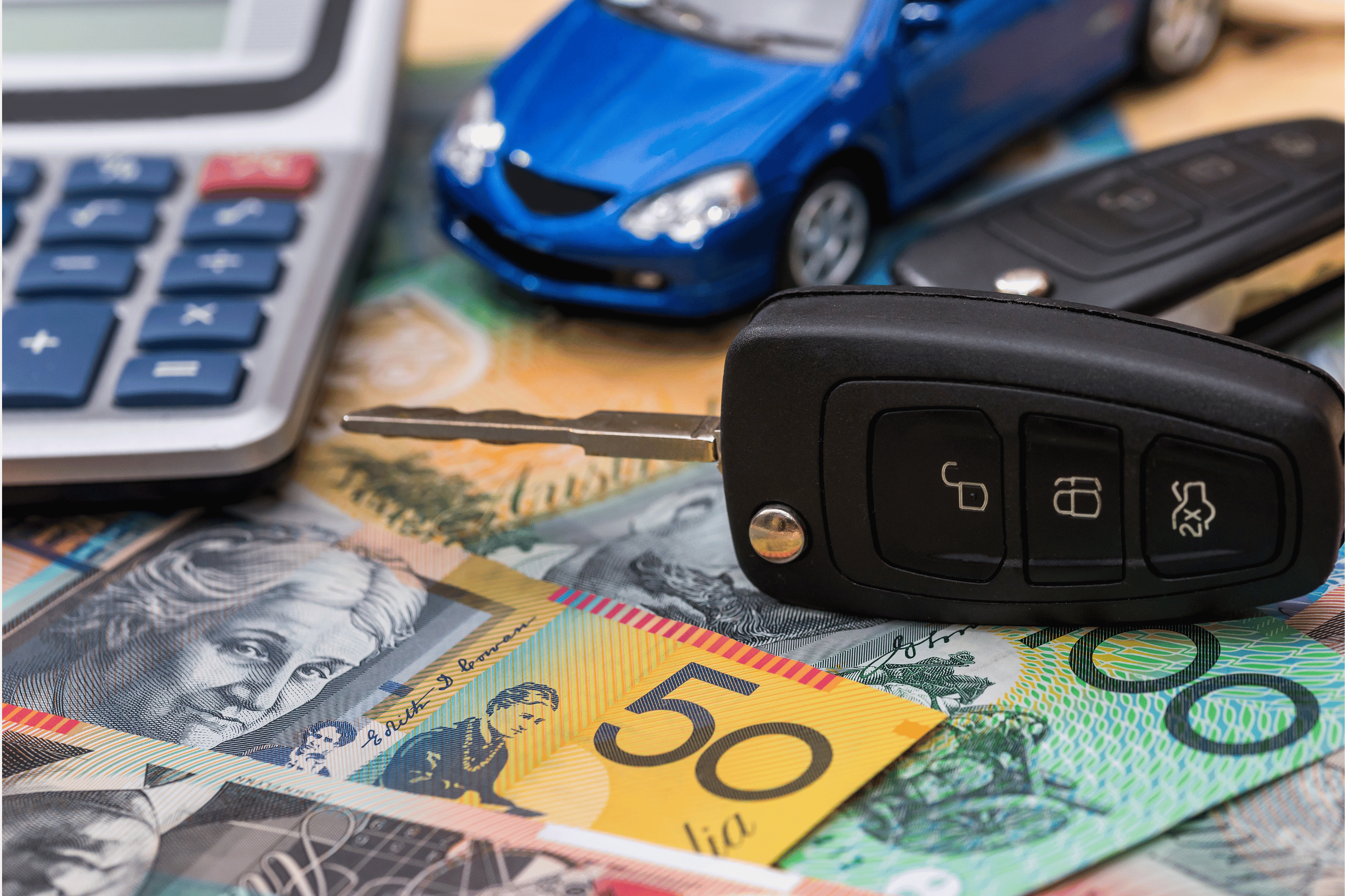 Car on keyboard with coins | Featured image for the How to Pay Off Your Car Loan Faster Blog from Fido Finance.