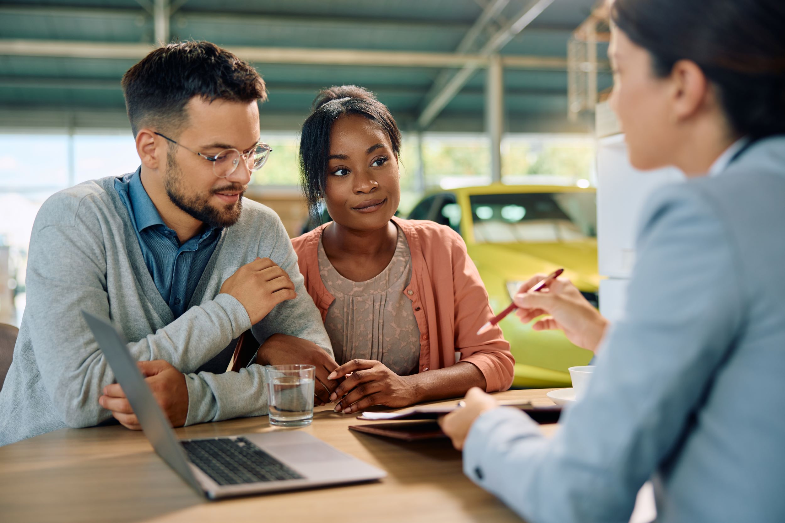 Young Multiracial Couple About To Sign Contract During A Meeting With Car Saleswoman | Featured image for the Our Top 6 Tips for Financing a Car with Bad Credit Blog from Fido Finance.