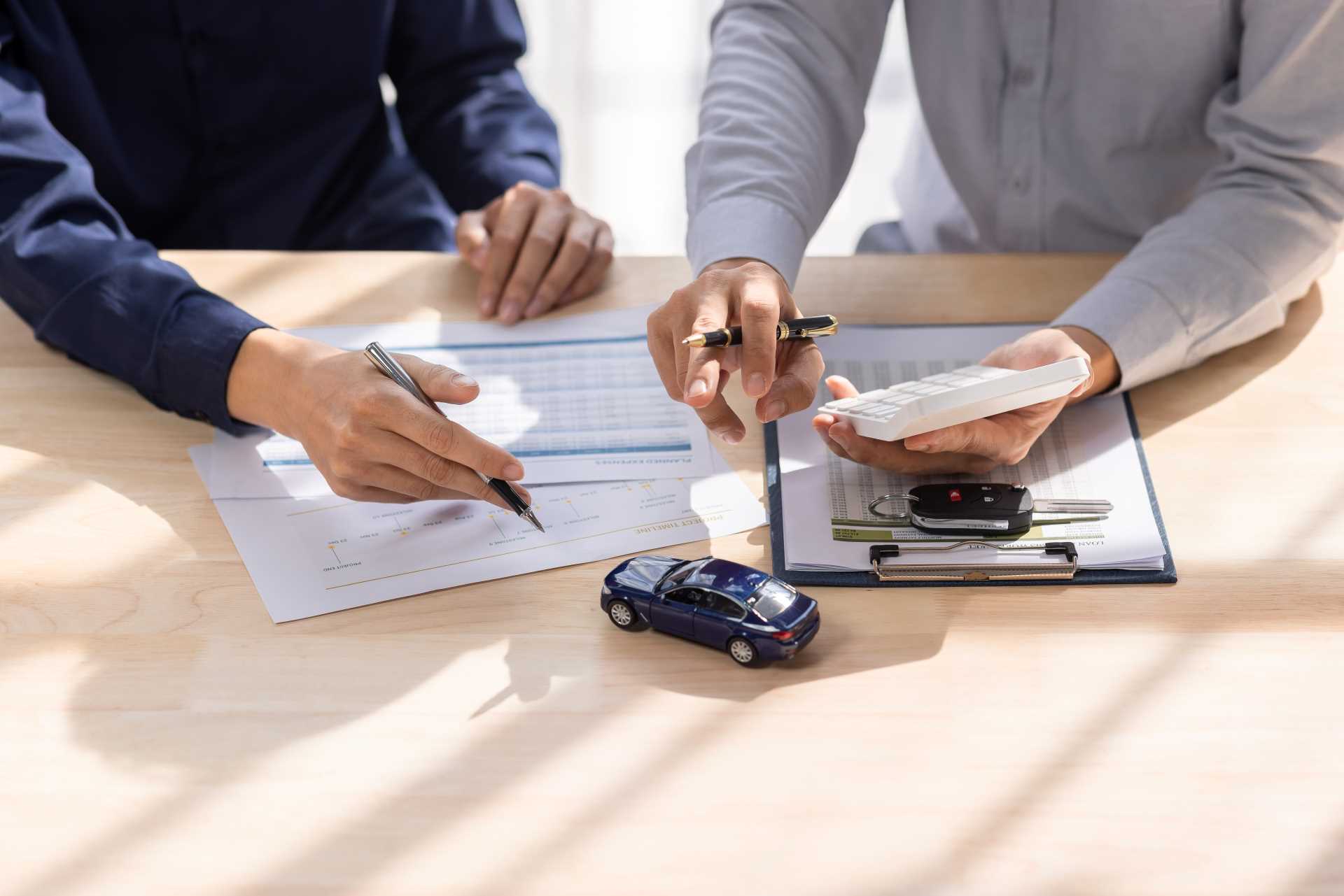 People working on a car loan document | Featured image for the Exploring Fixed vs Variable Rate Loans for Cars Blog from Fido Finance.