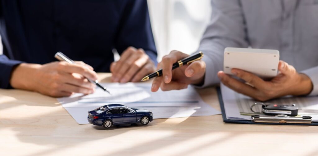 People working on a car loan document | Featured image for the Exploring Fixed vs Variable Rate Loans for Cars Blog from Fido Finance.