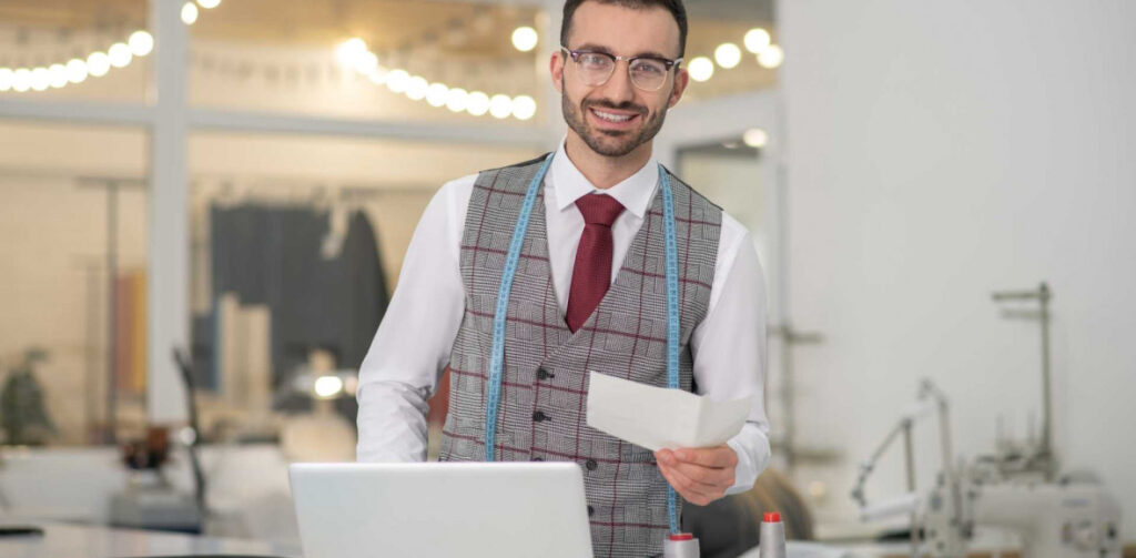 Male tailor standing over his workspace | Featured image for the ABN Loans: What You Should Know blog from Fido Finance.